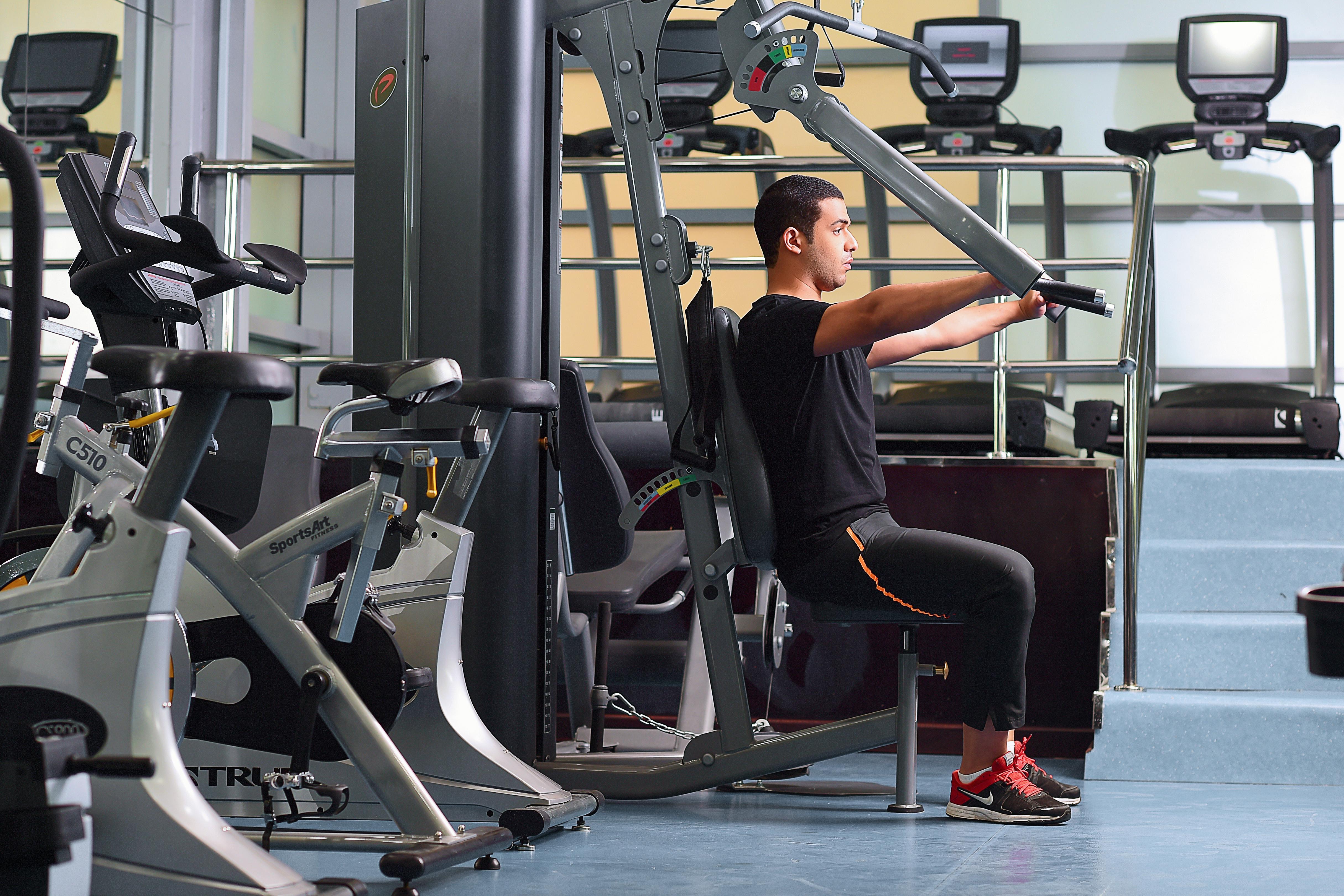 Saraya Corniche Hotel Doha Exterior foto A man using a shoulder press machine